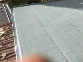 Flachdach mit grauer, strukturierter Oberfläche und Metallrand.
