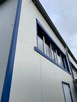 Moderne Gebäude-Fassade mit blauen Akzenten und großen Fenstern.