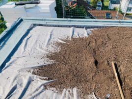 Flachdach mit Bitumenbahnen, abgedeckt mit einer Schicht Erde für die Dachbegrünung.